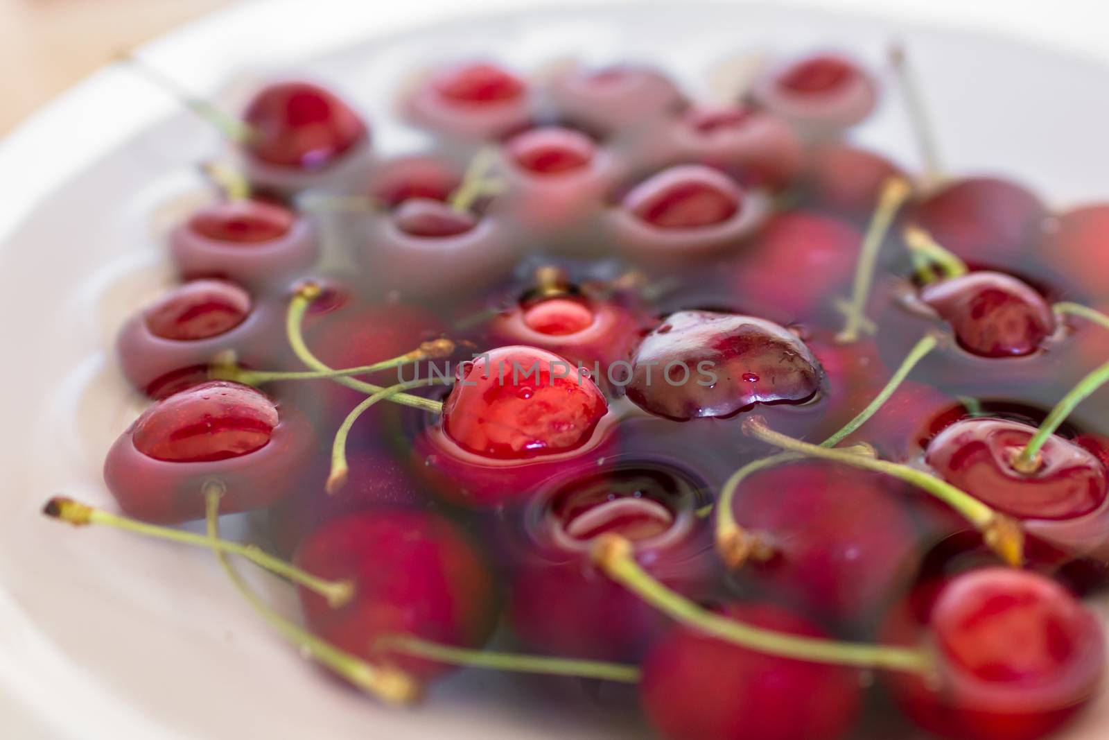 Cherries immersed in water during cleaning.