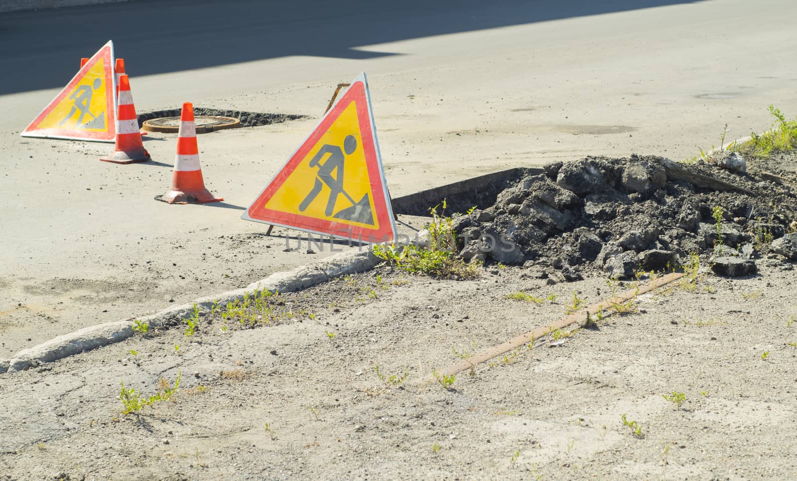 signs of road repair and sidewalk