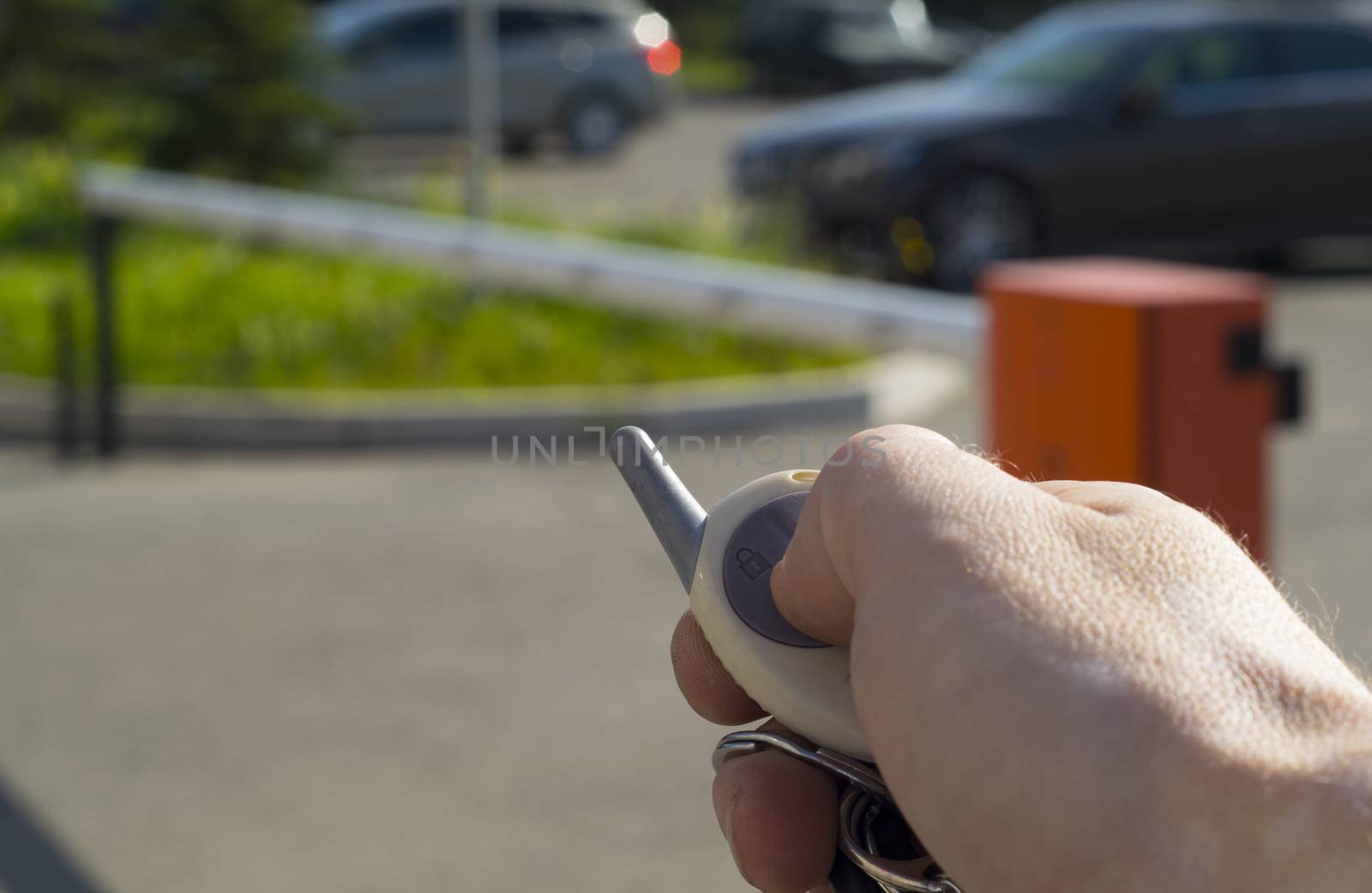 man with remote control automatic barrier opens