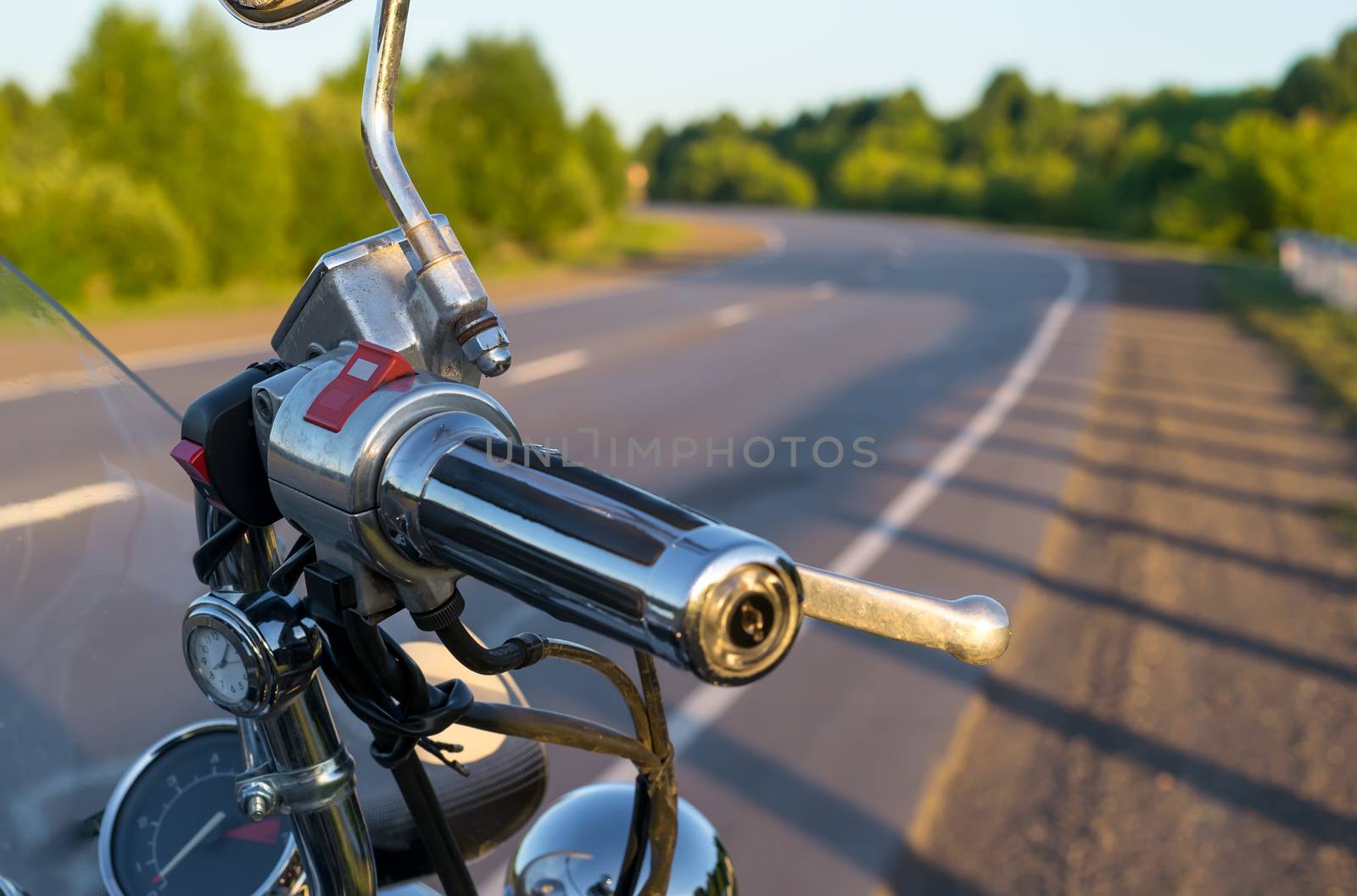 view of handlebar grips of the motorcycle on the country road background closeup