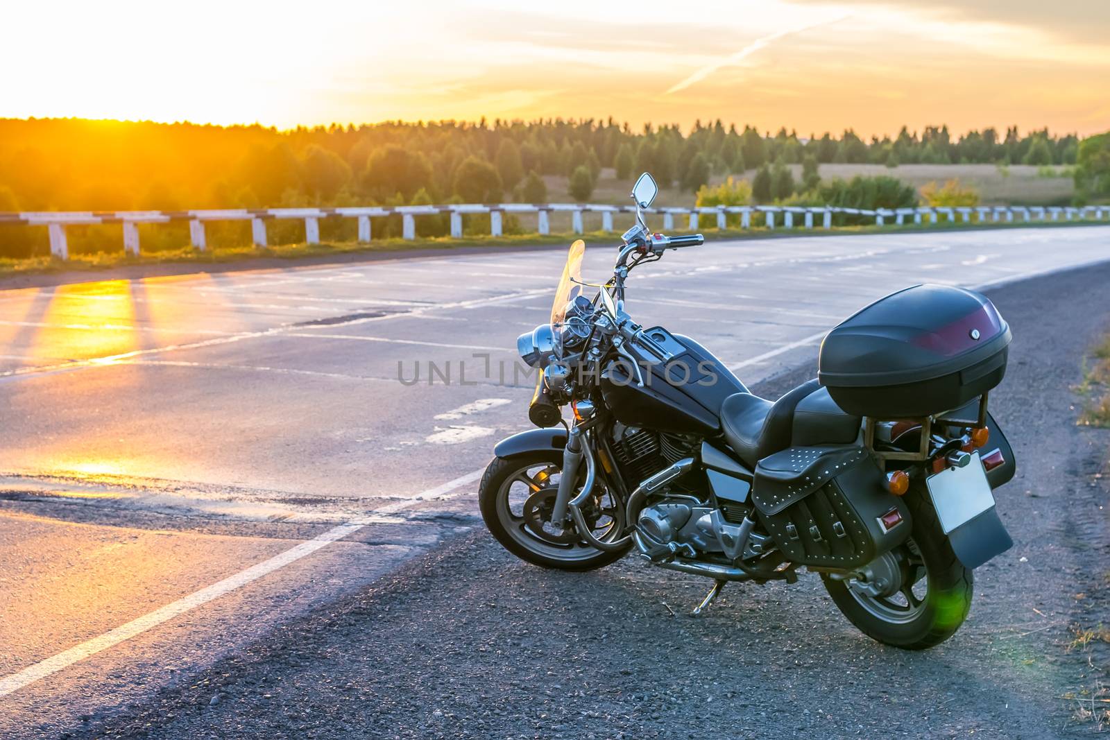 view of a cruise motorcycle on the road against the setting sun