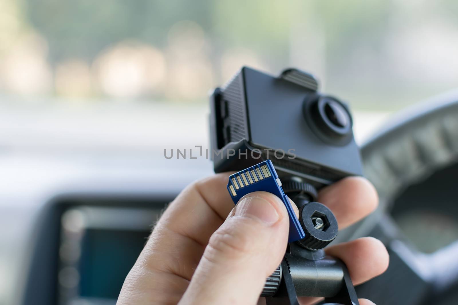the hand of a male car driver that holds a car DVR by jk3030