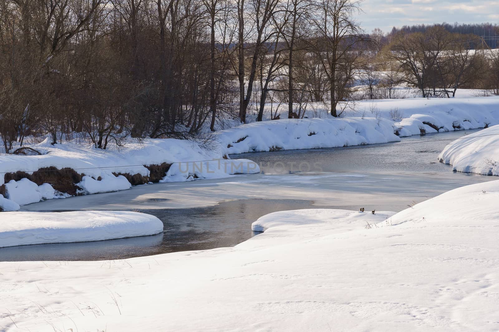 river on a winter day partially covered with ice by VADIM