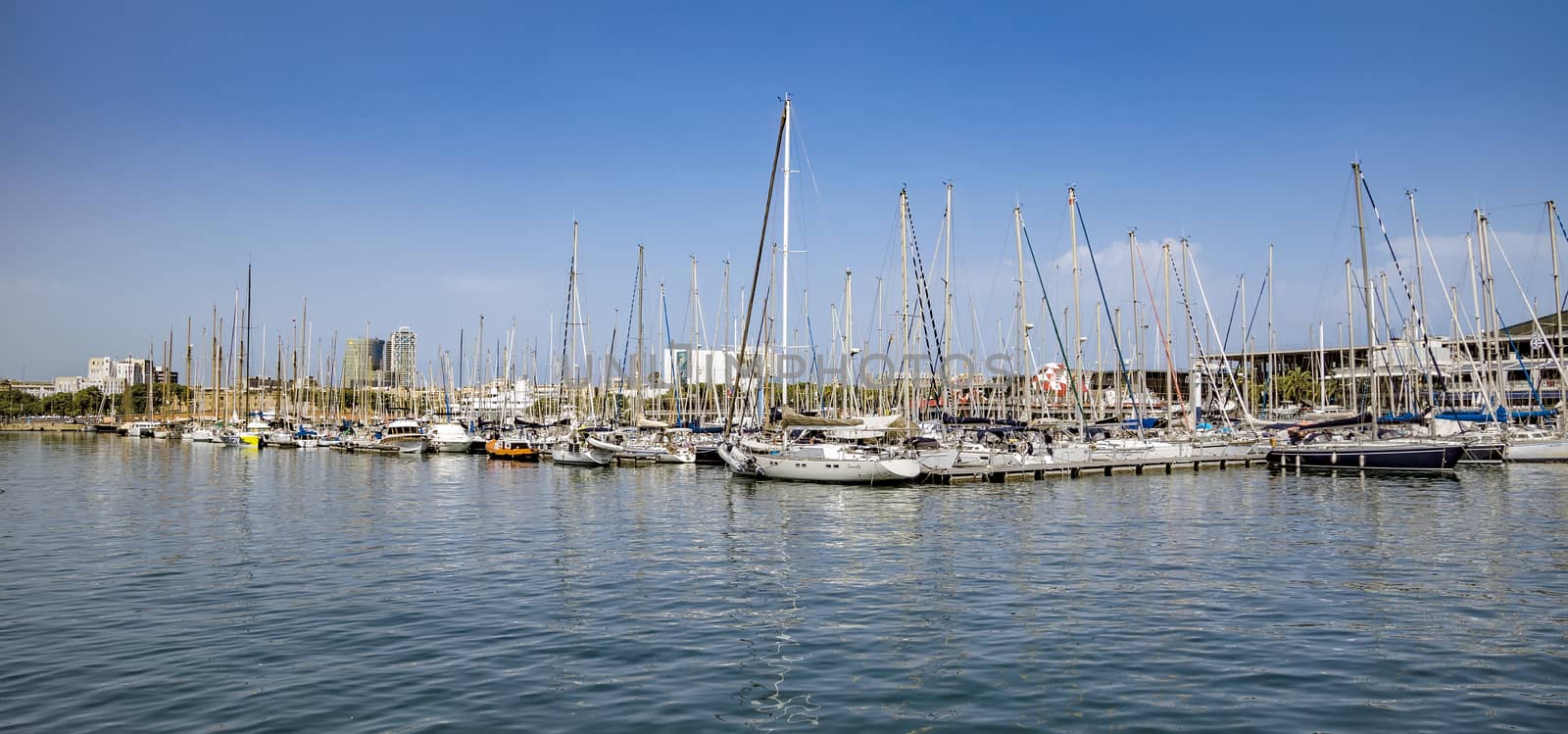 Yachts and sailboats moored in the Port Vell of Barcelona by Venakr