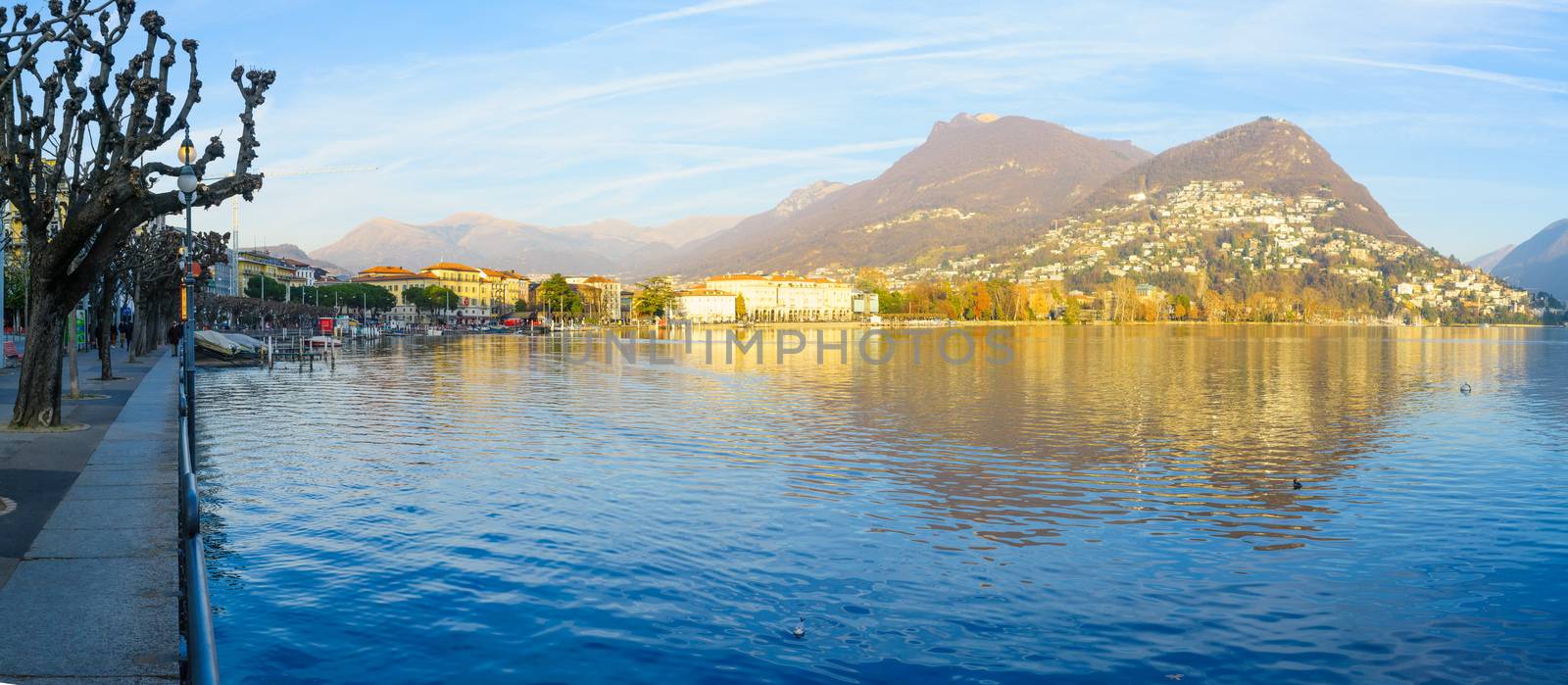 LUGANO, SWITZERLAND - DECEMBER 29, 2015: Panoramic view of the lakeside promenade, with locals and visitors, in Lugano, Ticino, Switzerland