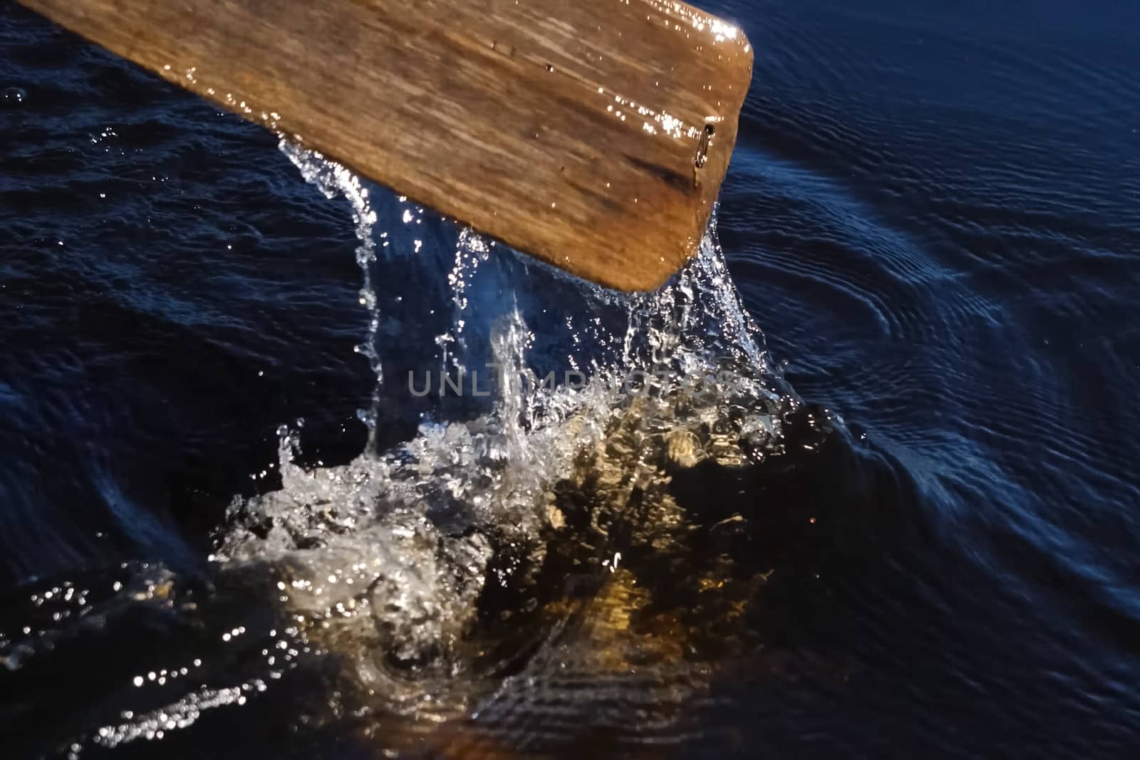 Paddle over surface of the water. Rowing a paddle in the river. by DePo