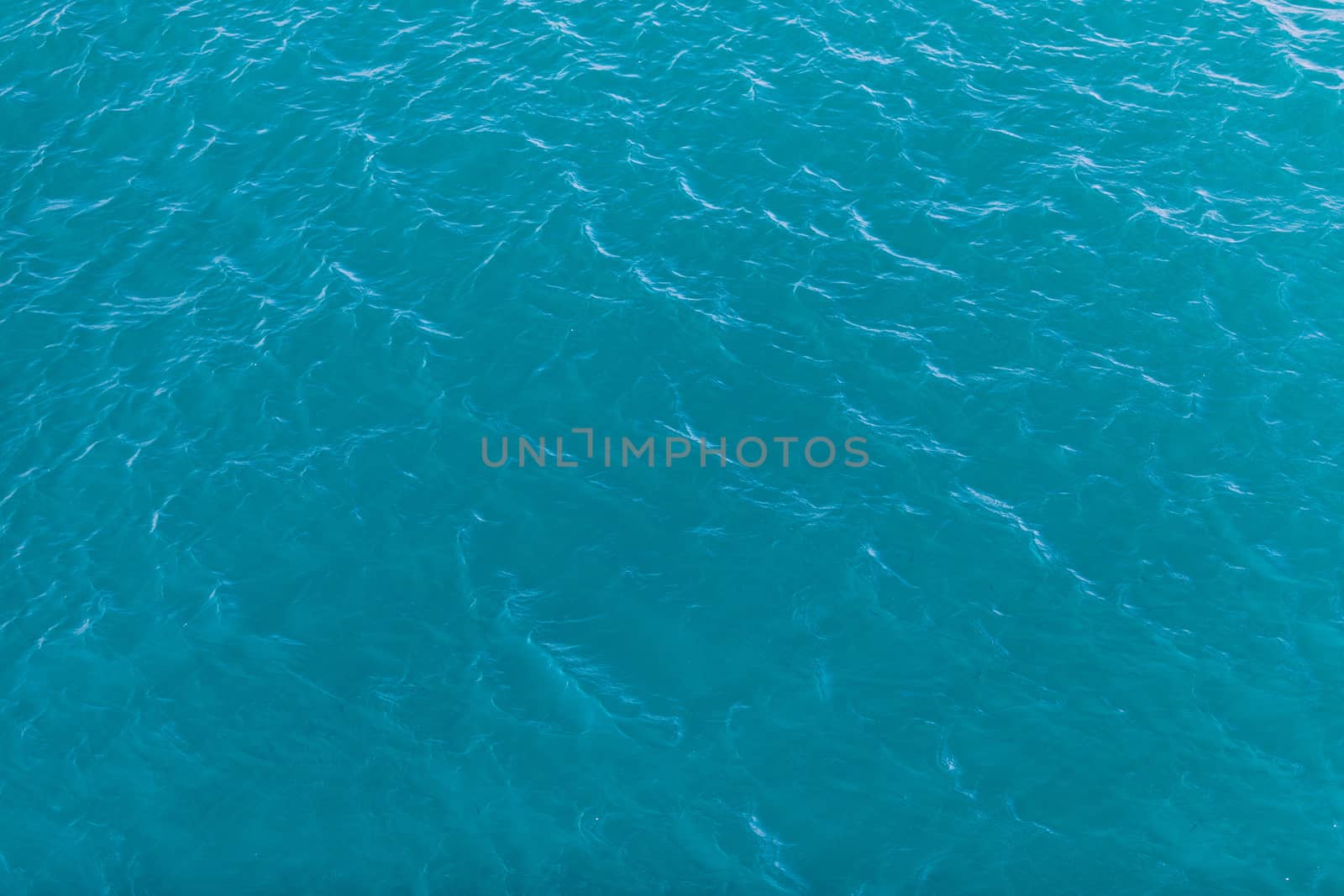 Background shot of aqua sea water surface. Sea surface aerial view. Waving water surface of the sea background.