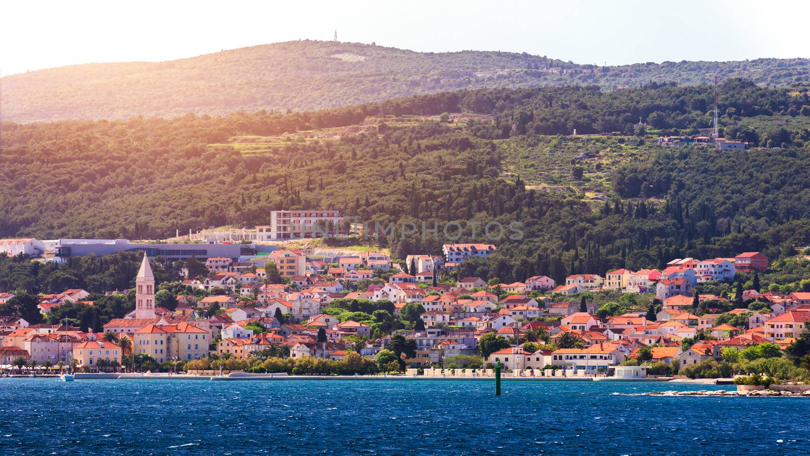 Supetar city in Brac island, Croatia. View from the sea. Picturesque scenic view on Supetar on Brac island, Croatia. Panoramic view on harbor of town Supetar from the side of sea. Brac, Croatia.