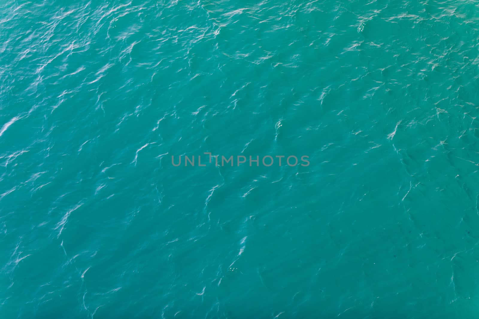 Background shot of aqua sea water surface. Sea surface aerial view. Waving water surface of the sea background.