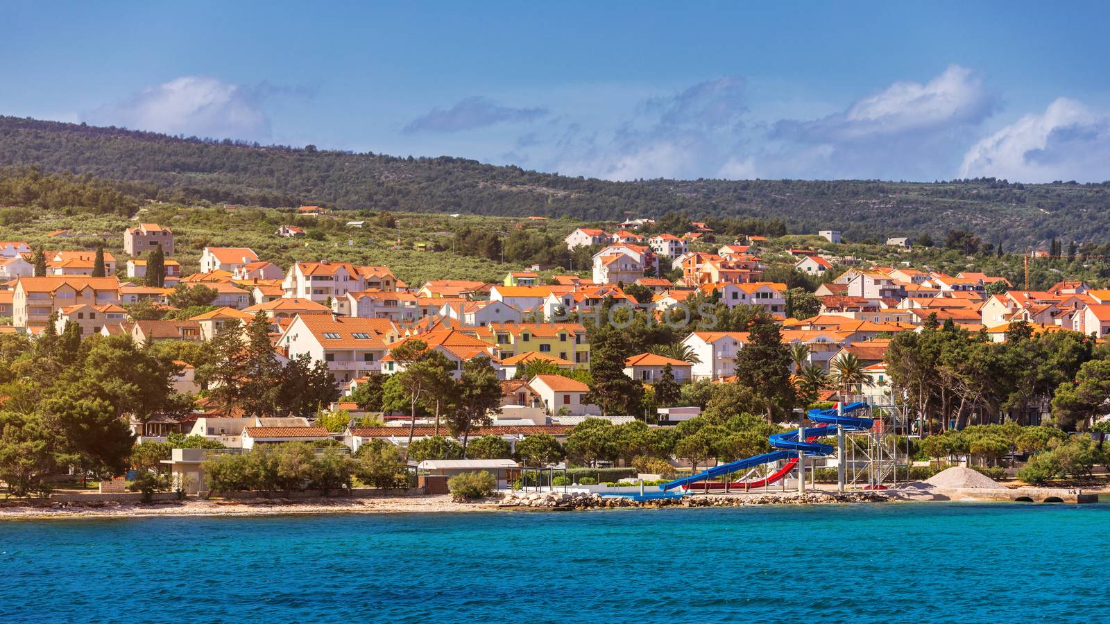 Supetar city in Brac island, Croatia. View from the sea. Picturesque scenic view on Supetar on Brac island, Croatia. Panoramic view on harbor of town Supetar from the side of sea. Brac, Croatia.