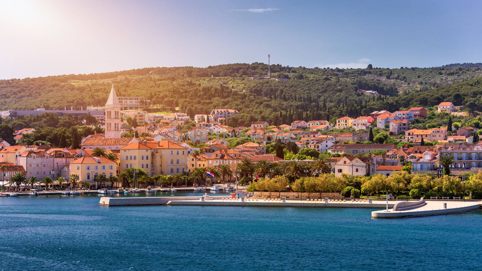 Supetar city in Brac island, Croatia. View from the sea. Picturesque scenic view on Supetar on Brac island, Croatia. Panoramic view on harbor of town Supetar from the side of sea. Brac, Croatia.