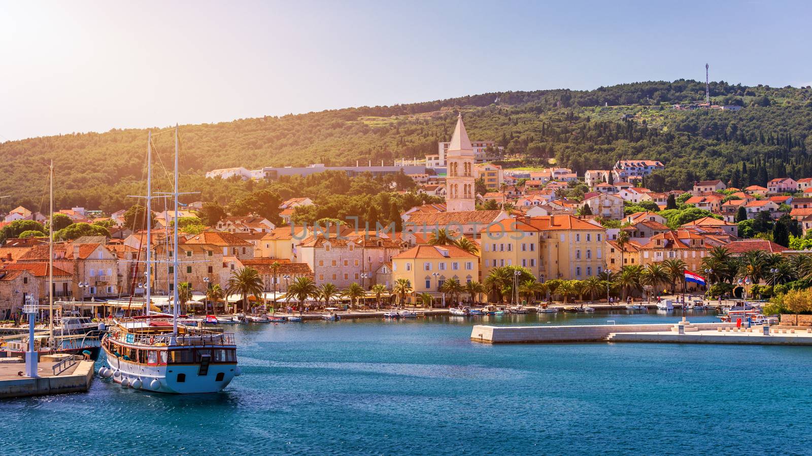 Supetar city in Brac island, Croatia. View from the sea. Picturesque scenic view on Supetar on Brac island, Croatia. Panoramic view on harbor of town Supetar from the side of sea. Brac, Croatia.