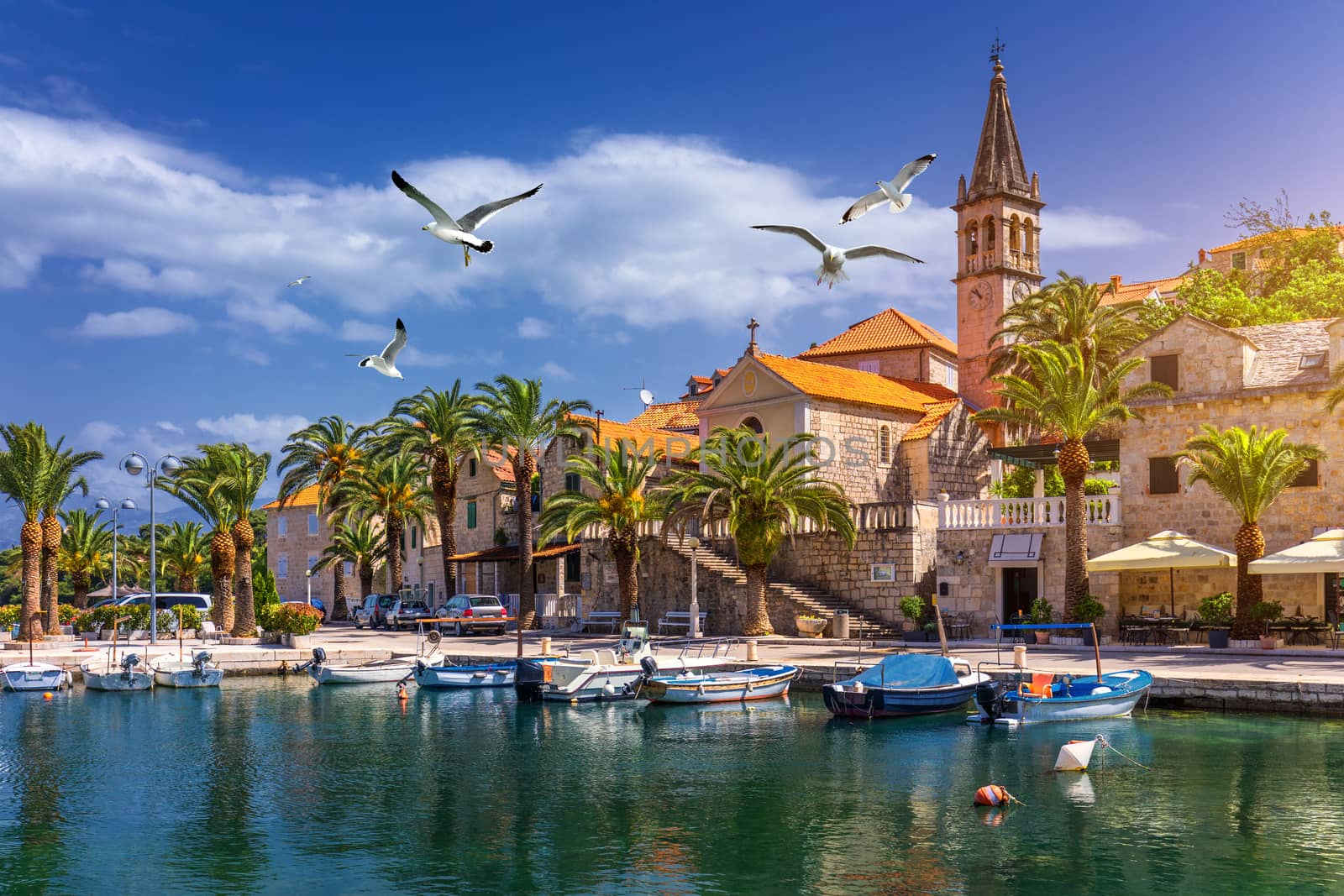 Splitska village with beautiful port and seagull's flying over the village, Brac island, Croatia. Fishing boats in Splitska village on Brac island seafront view, Dalmatia, Croatia, Croatia.