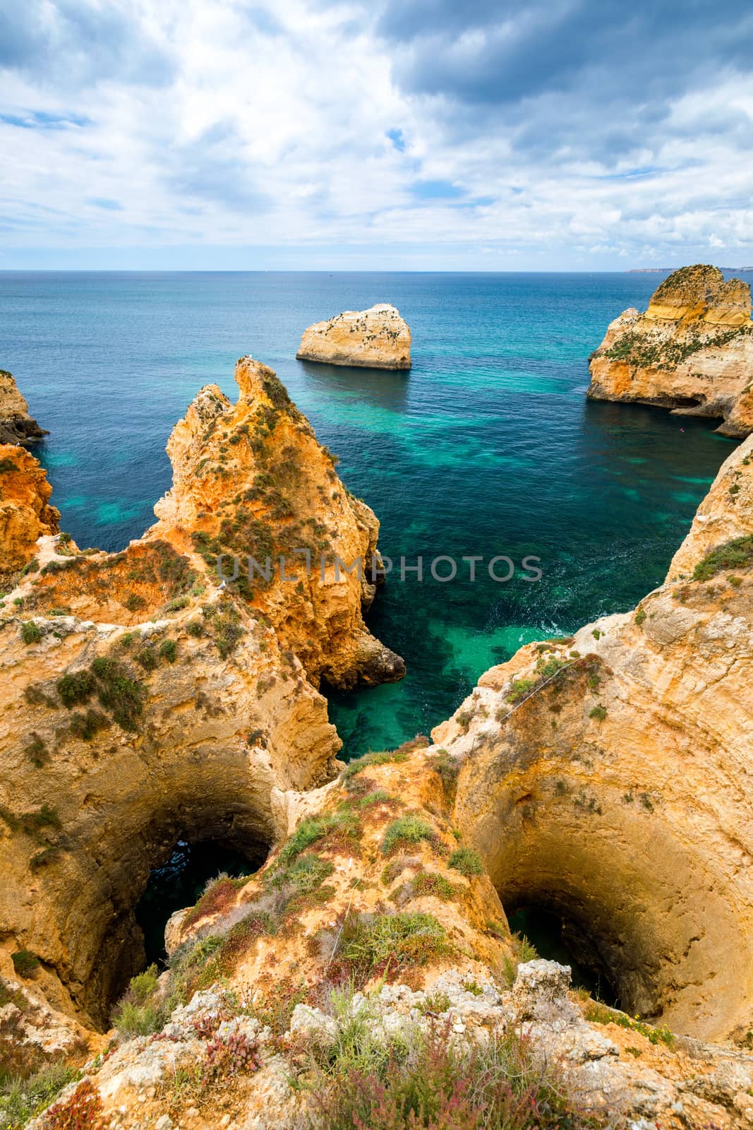 View of stunning beach with golden color rocks in Alvor town , Algarve, Portugal. View of cliff rocks on Alvor beach, Algarve region, Portugal.