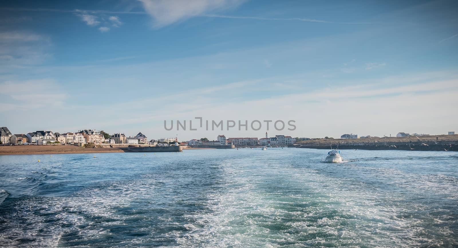 Saint Gilles Croix de Vie, France - September 16, 2018: A small fishing boat sailing at the port exit on a summer day