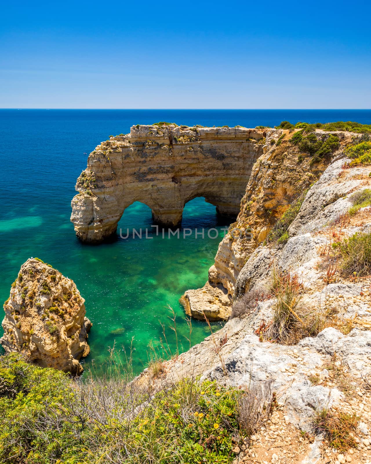 Natural caves at Marinha beach, Algarve Portugal. Rock cliff arches on Marinha beach and turquoise sea water on coast of Portugal in Algarve region. 
