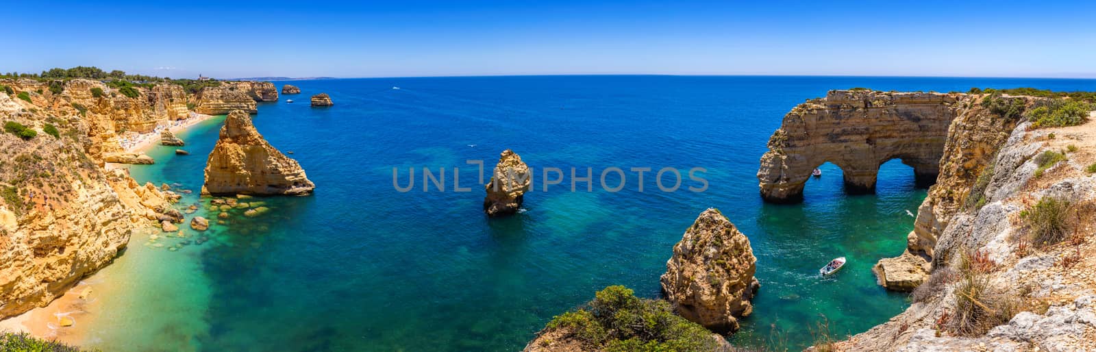 Natural caves at Marinha beach, Algarve Portugal. Rock cliff arches on Marinha beach and turquoise sea water on coast of Portugal in Algarve region. 