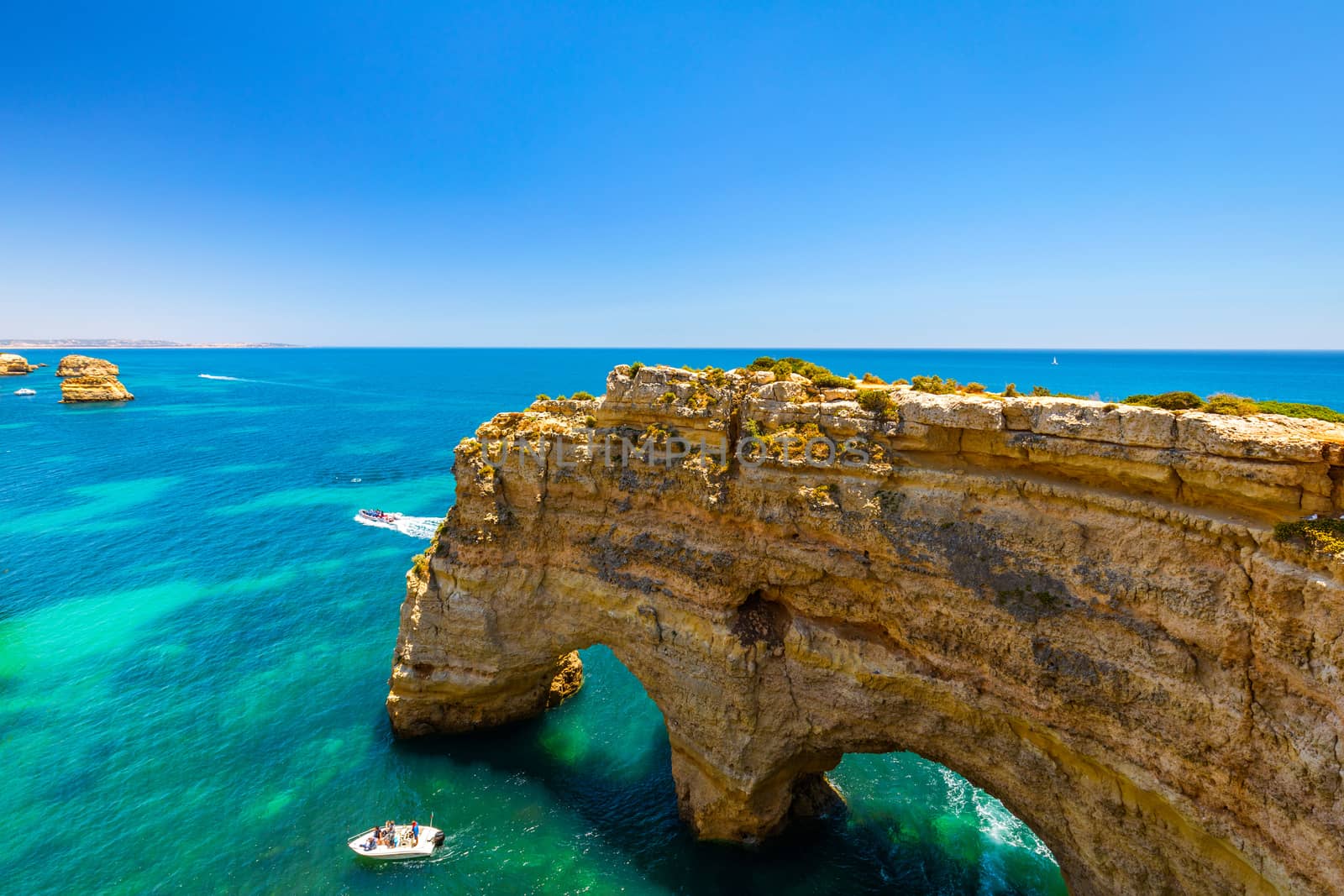Natural caves at Marinha beach, Algarve Portugal. Rock cliff arches on Marinha beach and turquoise sea water on coast of Portugal in Algarve region. 
