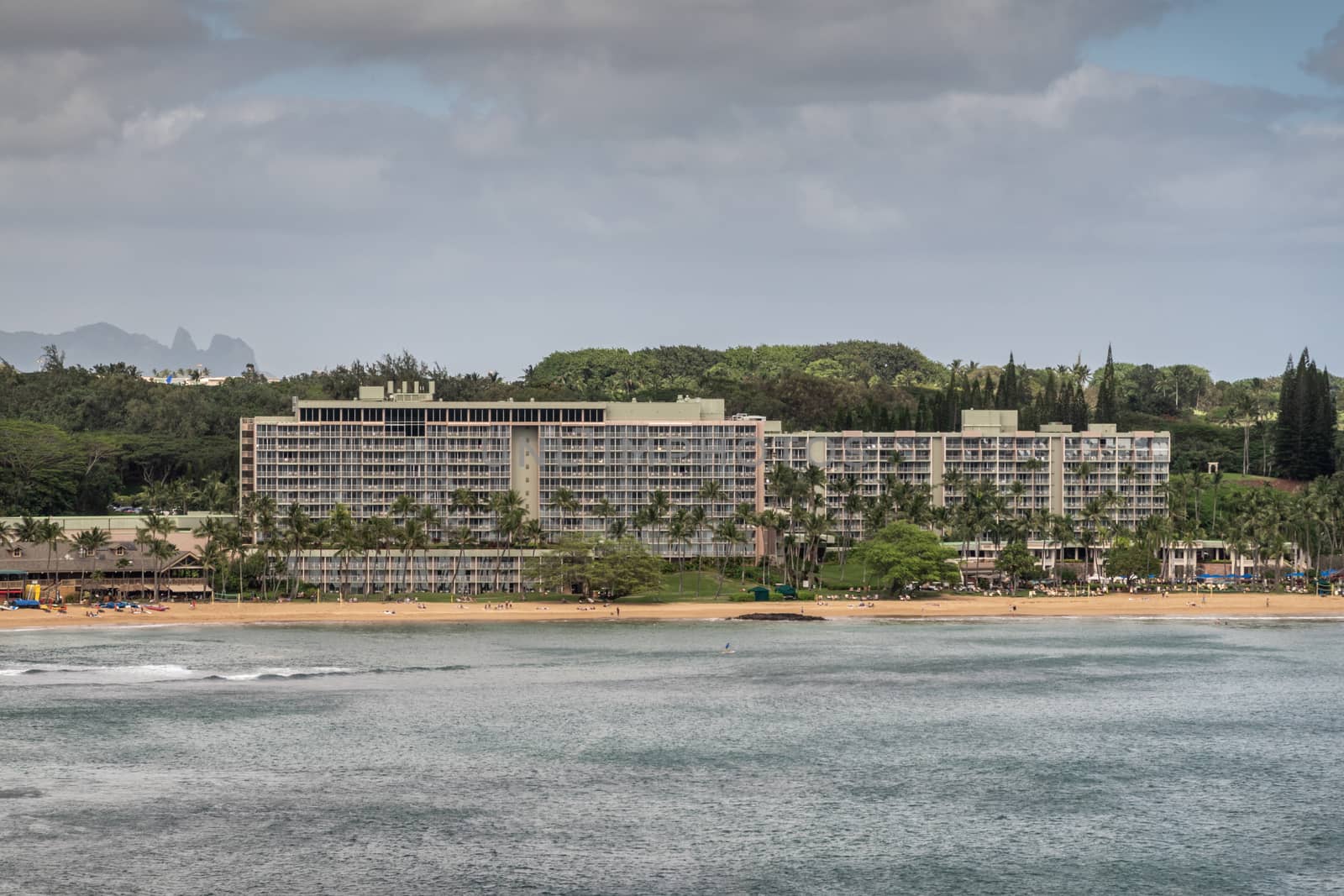 Nawiliwili, Kauai, Hawaii, USA. - January 17, 2020: Marriott Beach Resort buildings surrounded by green trees adjacent to the port. Gray ocean water under gray cloudscape.