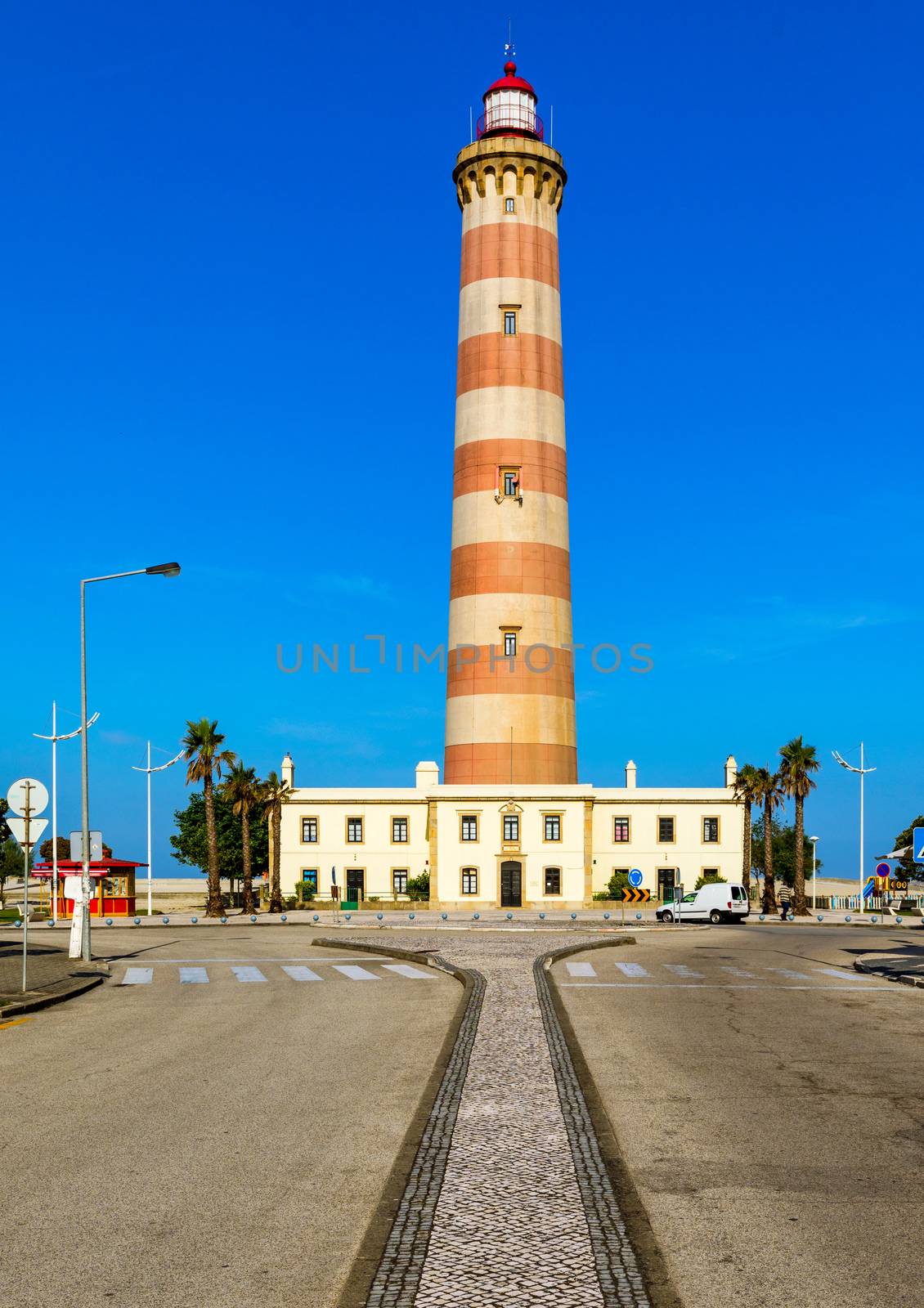 Lighthouse of Praia da Barra during the day, with a clear blue sky. View of the lighthouse of Barra beach (Praia da Barra) in Aveiro, Portugal. 