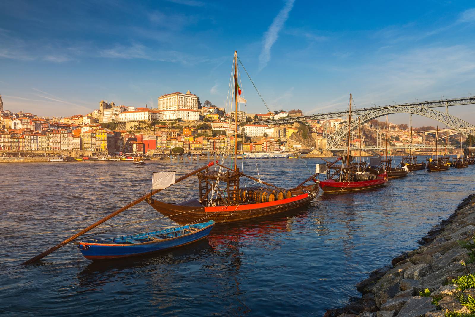 Port wine boats at the waterfront with Dom Luis bridge and the old town on the Douro River in Ribeira in the city centre of Porto in Porugal in Europe. Portugal, Porto