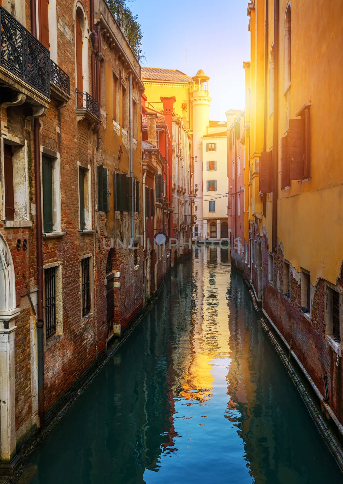 View of the street canal in Venice, Italy. Colorful facades of old Venice houses. Venice is a popular tourist destination of Europe. Venice, Italy.