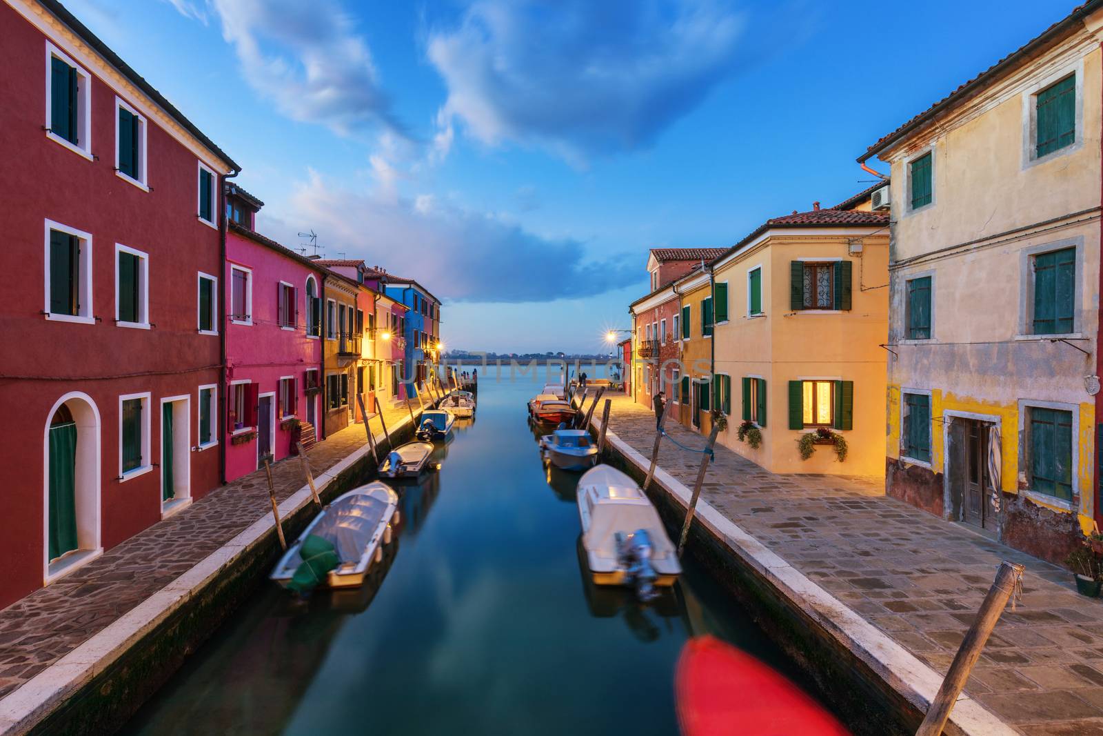 Street view with colorful buildings in Burano island at night, Venice, Italy. Architecture and landmarks of Burano, Venice postcard. Scenic canal and colorful architecture in Burano island near Venice, Italy