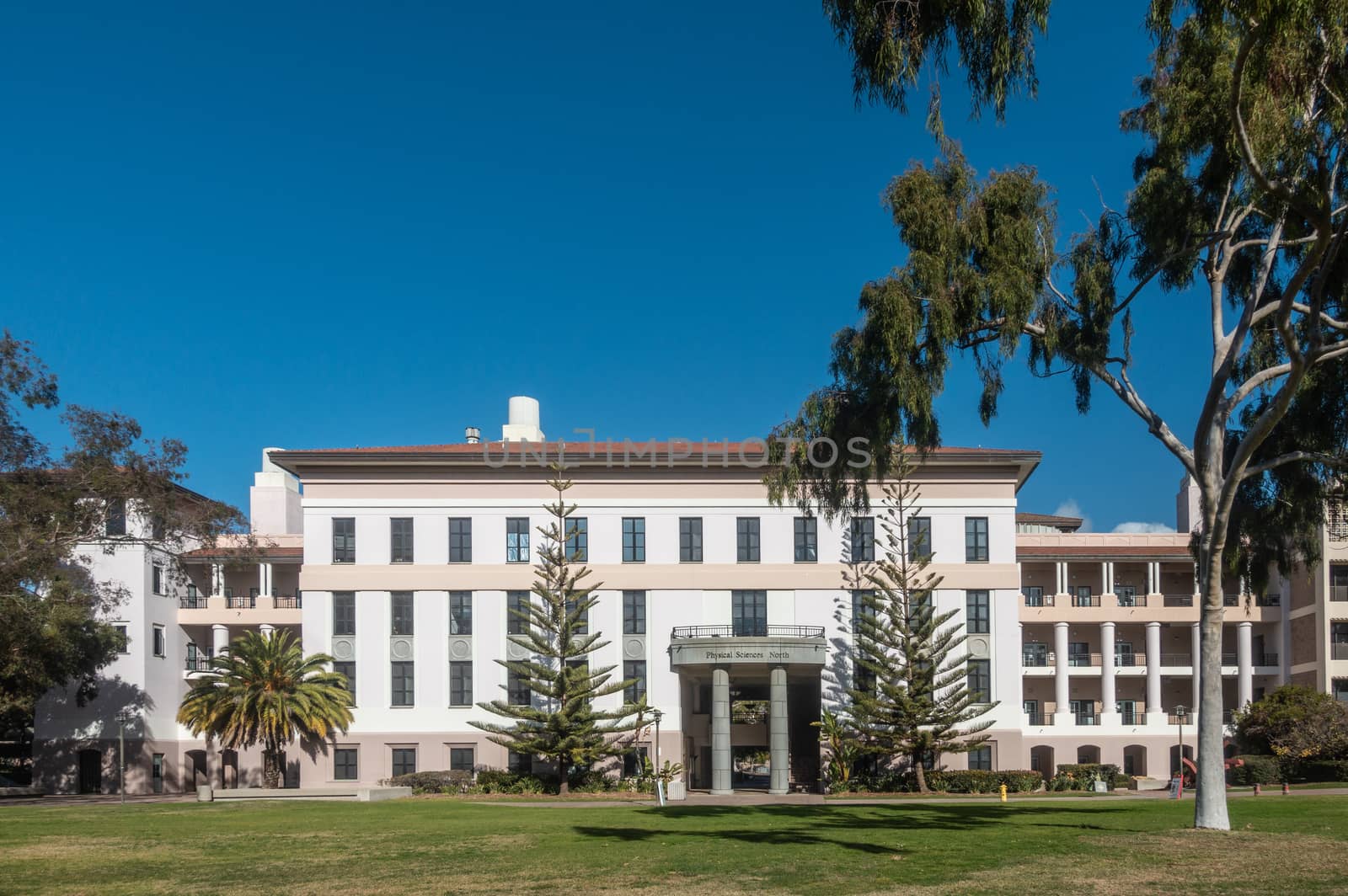 Santa Barbara, California, USA - January 6, 2019: The white and beige modern Physical Sciences North building of UCSB, behind green lawn, trees, and under blue sky.