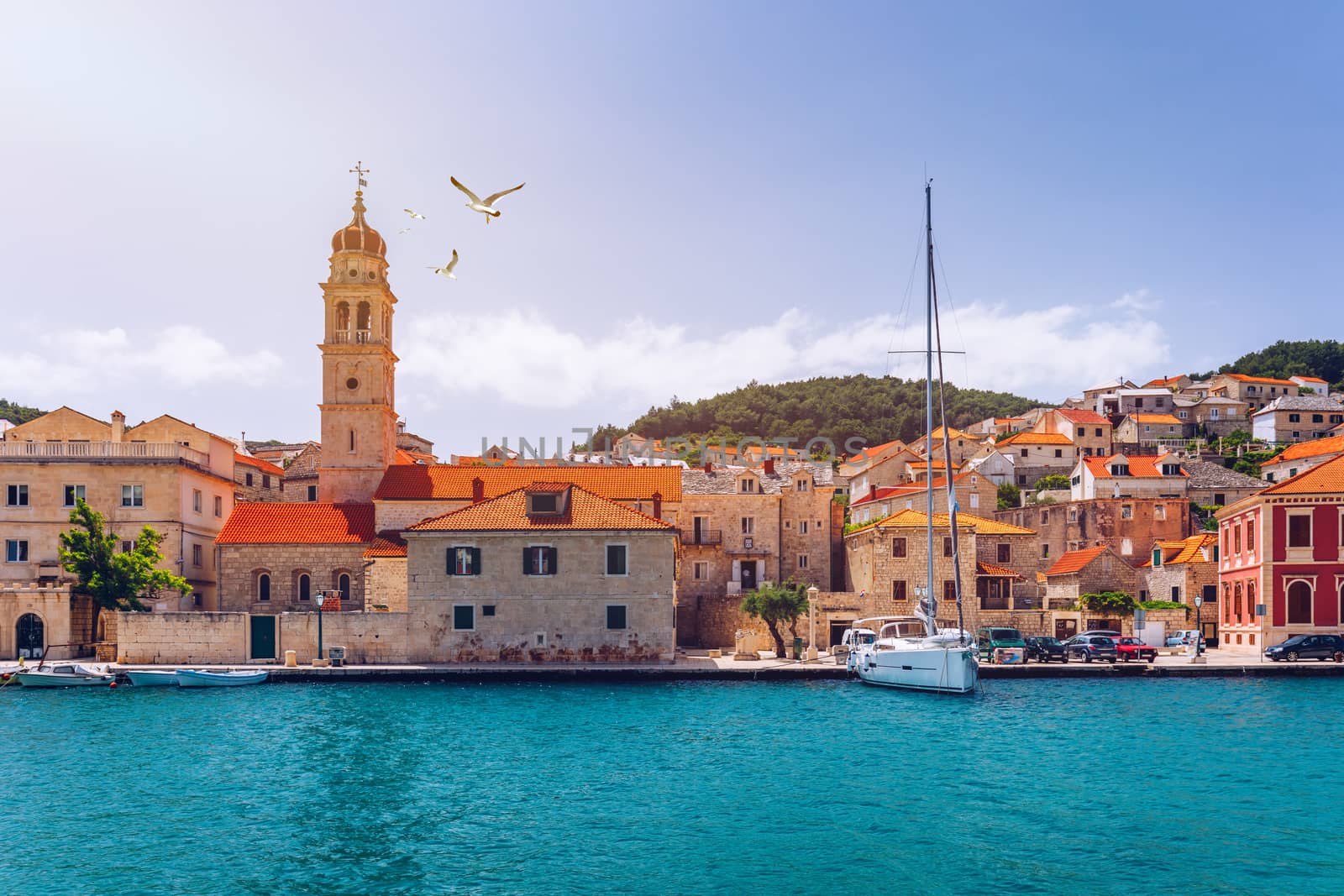 Panorama of picturesque town Pucisca in Croatia, Island Brac, Europe. Pucisca town mediterranean panorama with seagull's flying over the town. Croatia, Island Brac, Europe.