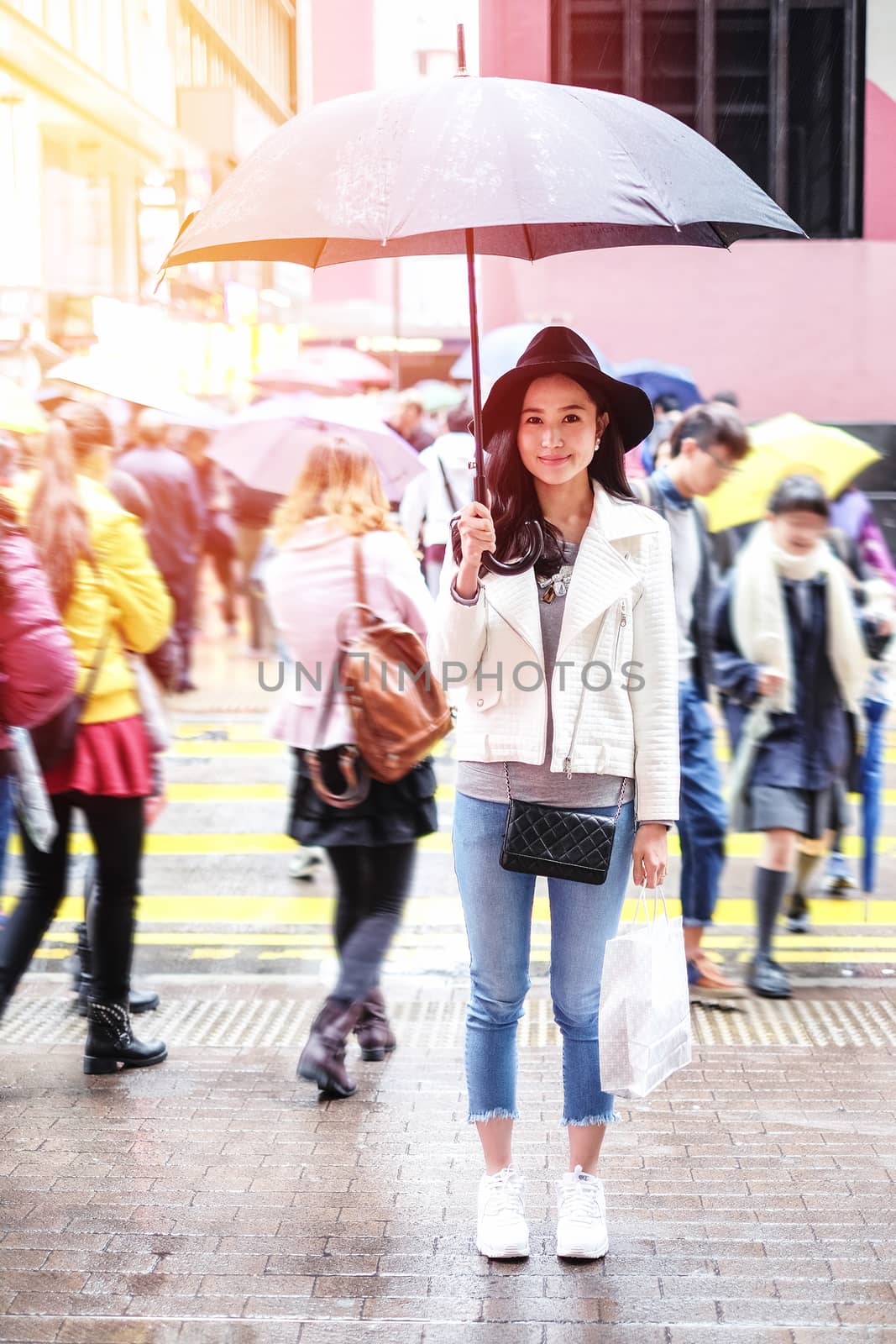 beautiful woman with shopping bags on the street in the rainny d by Surasak