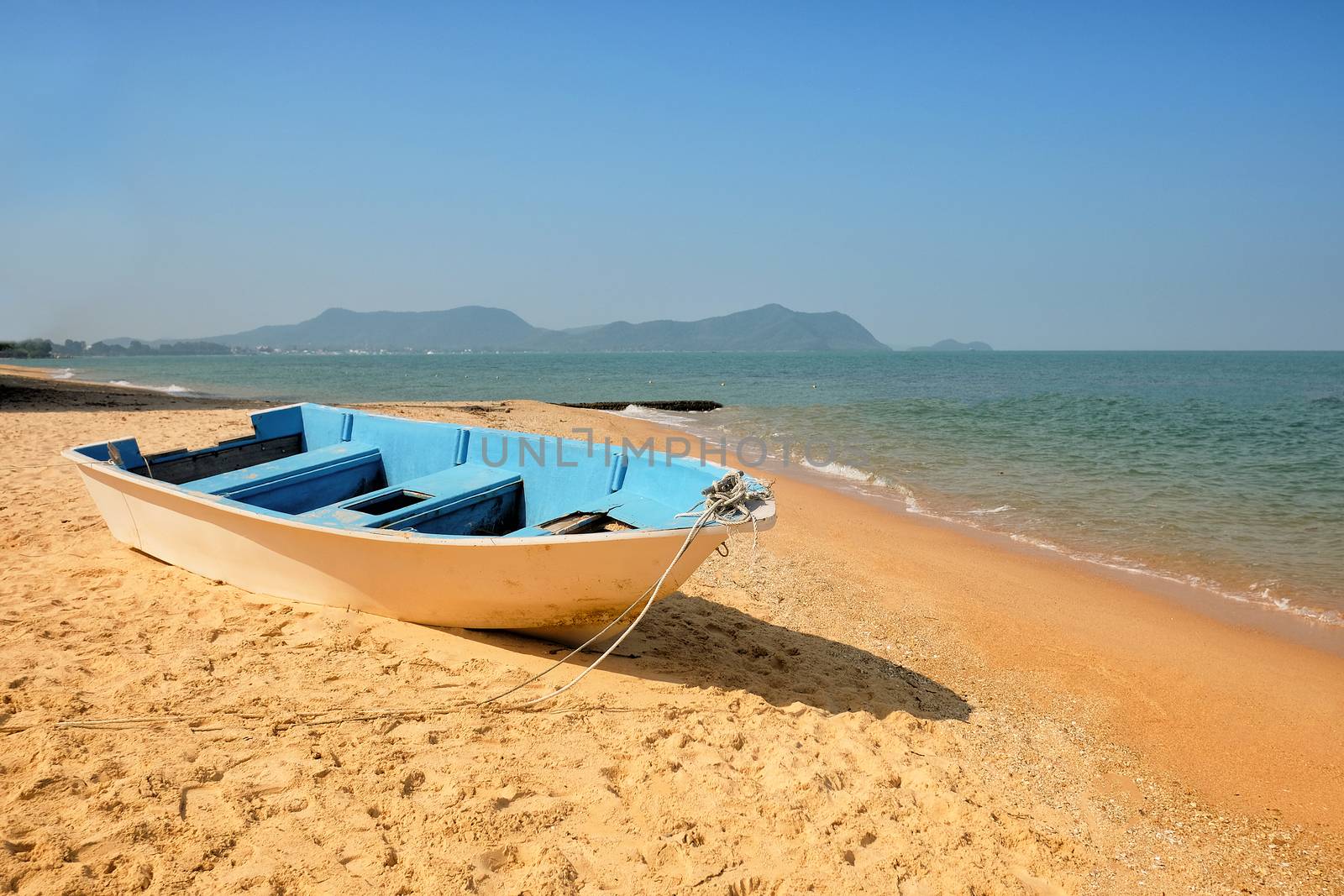 Fishing boat on sand with blue sky 