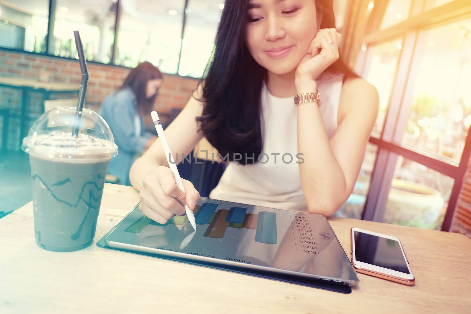 close up of a business woman analyzing business graphs on digita by Surasak