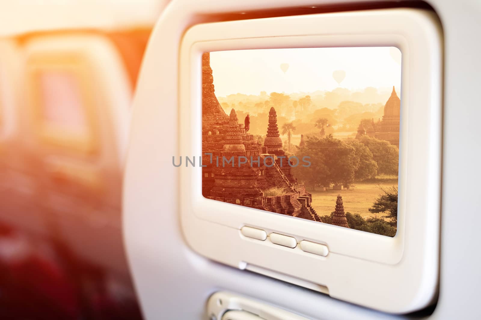 Aircraft monitor in front of passenger seat showing Bagan temple by Surasak