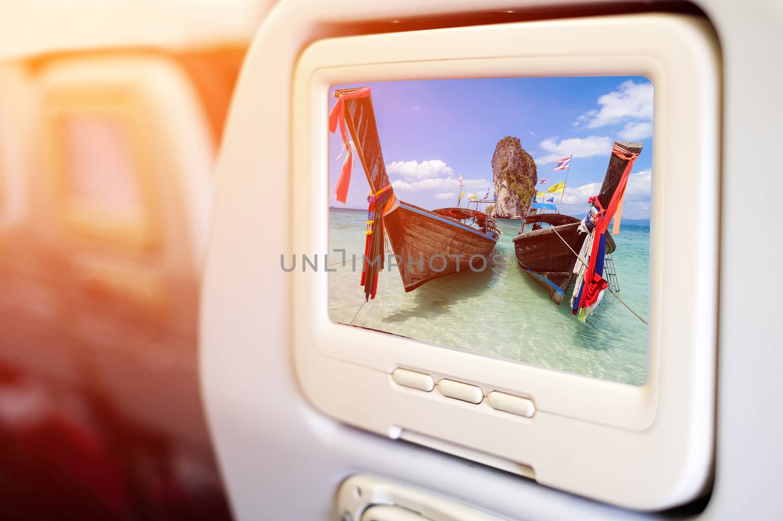 Aircraft monitor in front of passenger seat showing Thai boats a by Surasak