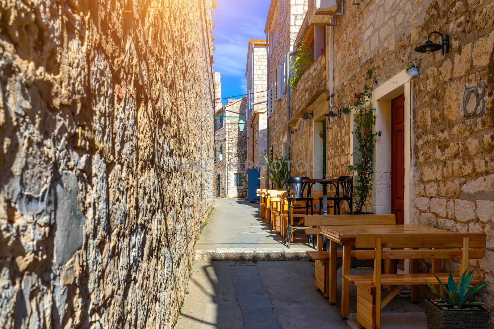 Beautiful street with flowers in the Hvar town, Hvar island, Dalmatia, Croatia. Old Mediterranean street, Hvar town. Old Adriatic town Hvar. Medieval street. Popular touristic destination of Croatia.