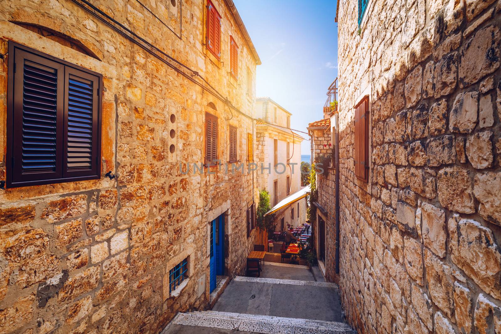 Beautiful street with flowers in the Hvar town, Hvar island, Dalmatia, Croatia. Old Mediterranean street, Hvar town. Old Adriatic town Hvar. Medieval street. Popular touristic destination of Croatia.