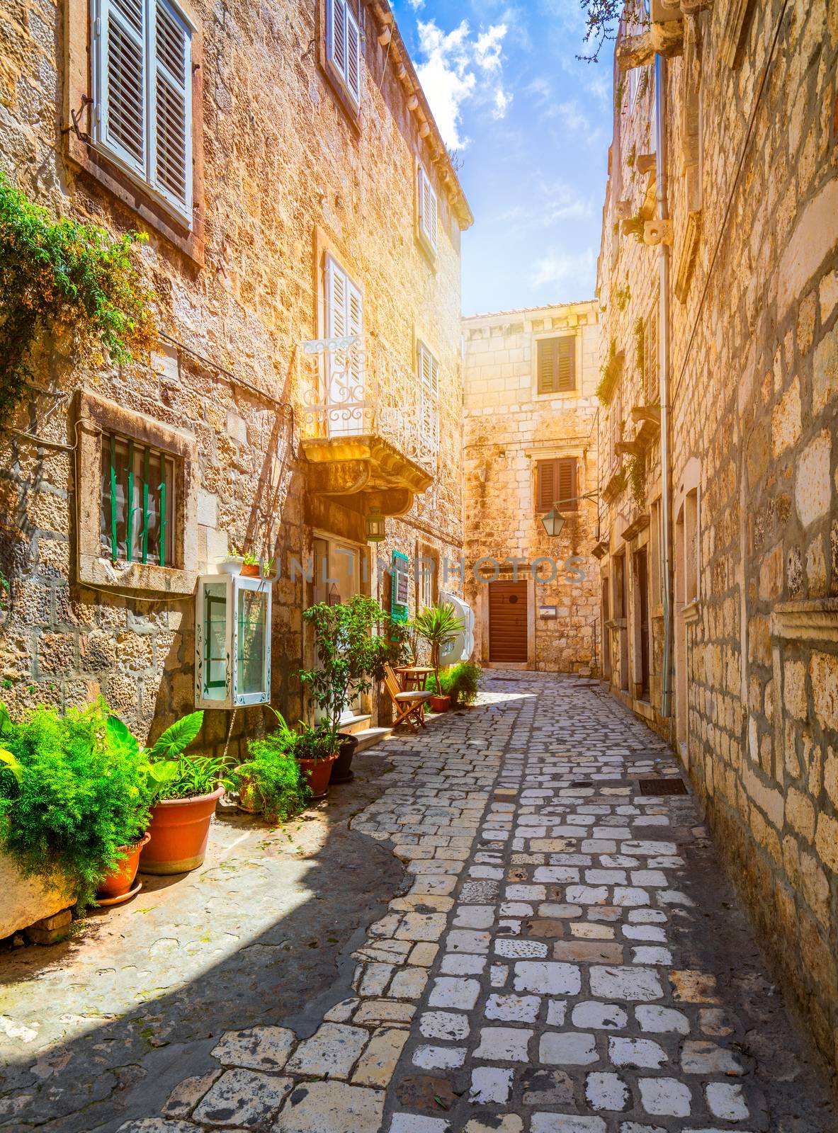 Beautiful street with flowers in the Hvar town, Hvar island, Dalmatia, Croatia. Old Mediterranean street, Hvar town. Old Adriatic town Hvar. Medieval street. Popular touristic destination of Croatia.
