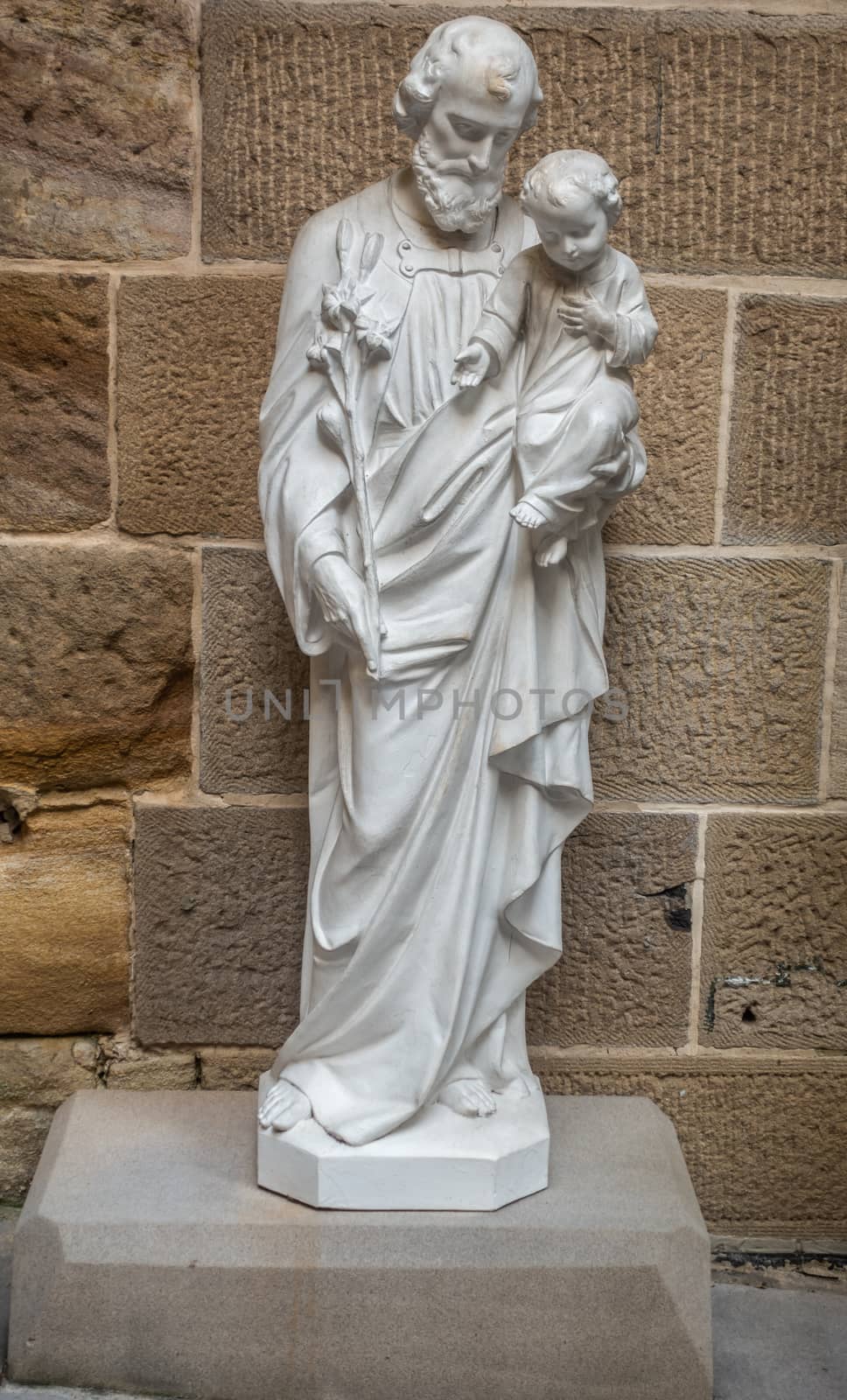 Sydney, Australia - February 12, 2019: Inside Saint Patricks Church on Grosvenor Street opposite of Lang Park. Closeup of white Saint Joseph with child statue on low pedestal at courtyard.