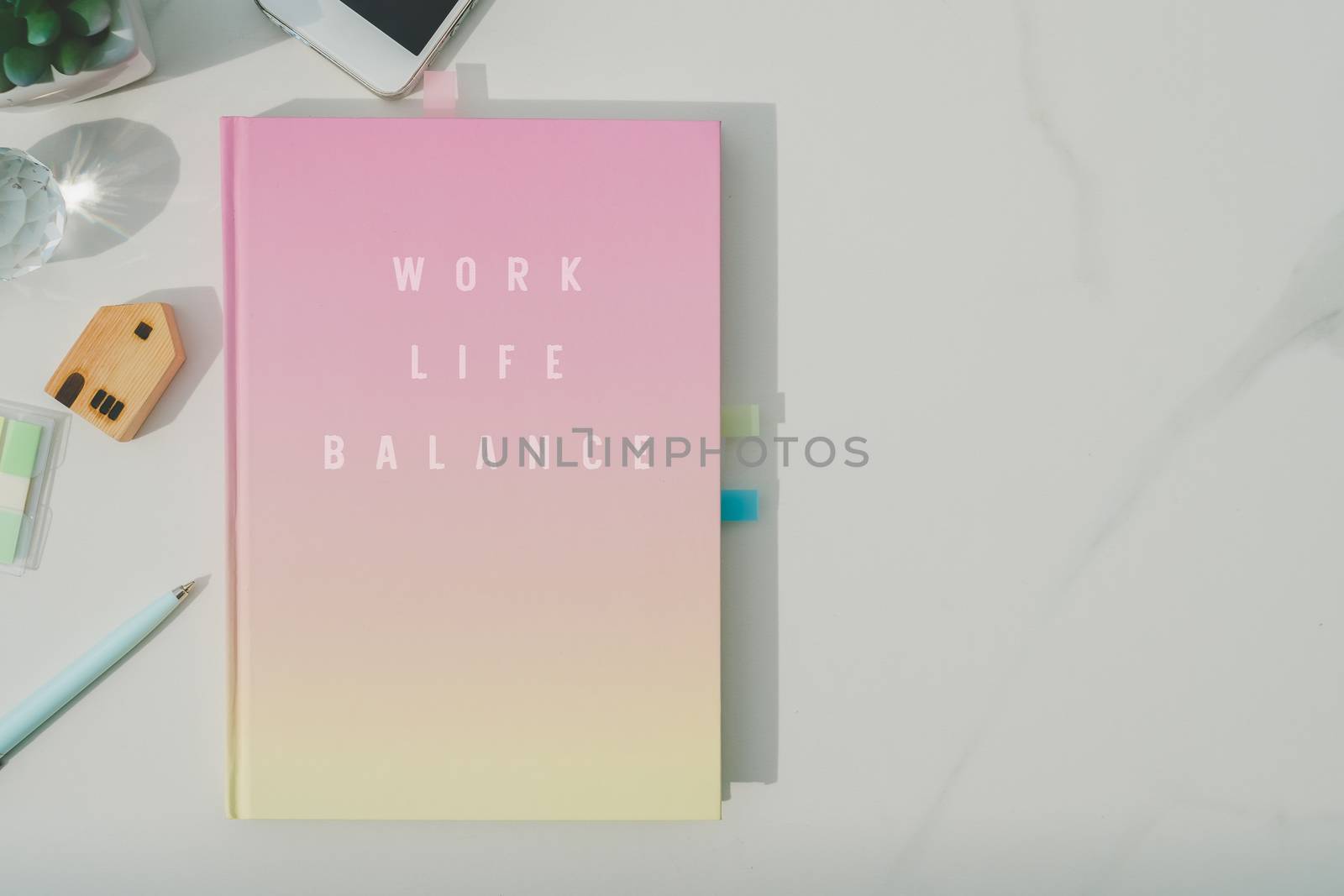 Colorful pastel white notebook for journal or diary on marble texture table.Work life balance quote phrase on book cover.