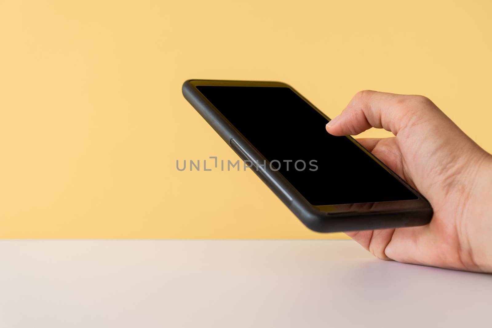 People hand using smartphone with blank yellow clear background. Business, financial, trade stock maket and social network. by Suwant