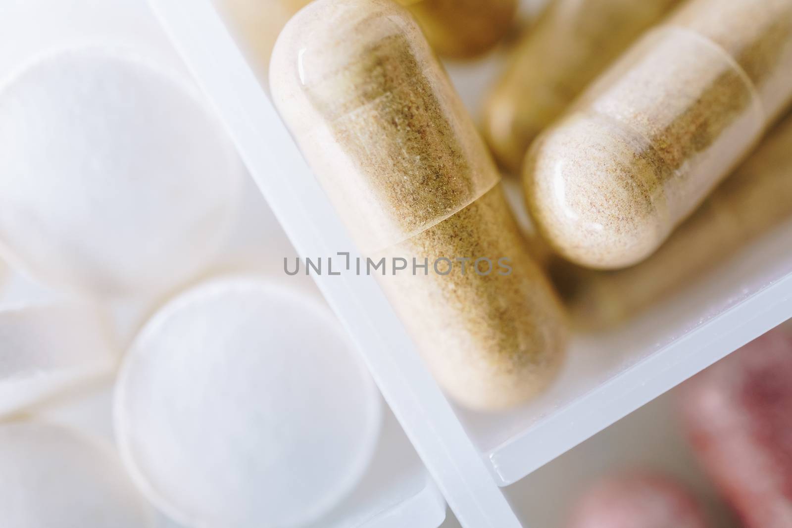 Top view of alternative organic medicine or herbal viatmin supplement capsule tablet on pill case  background. Concept of healthy eating. by Suwant