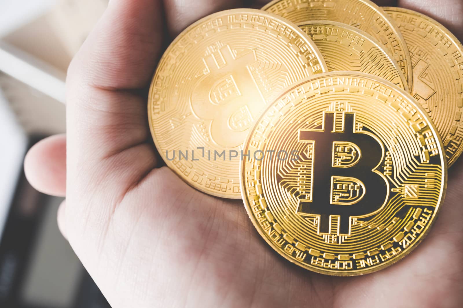 Hand hold a symbol of Bitcoins as digital money cryptocurrency background.