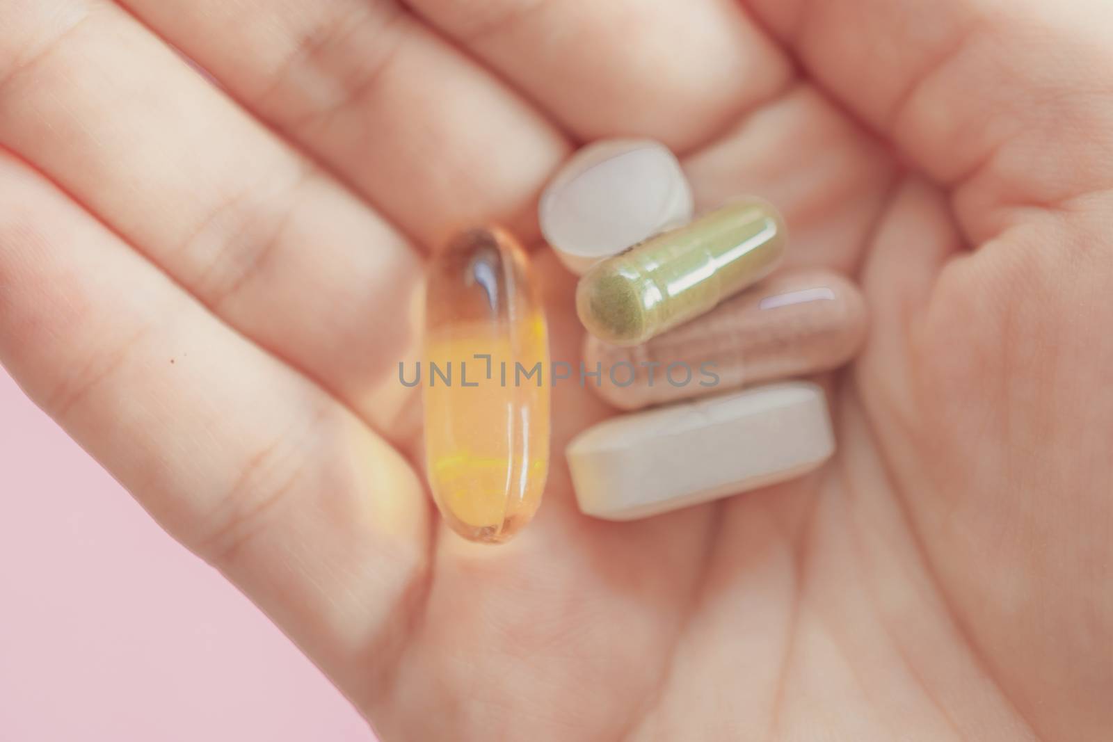 Top view of alternative organic medicine or herbal viatmin supplement capsule tablet on woman hand with copyspace background. Concept of healthy eating lifestyle.