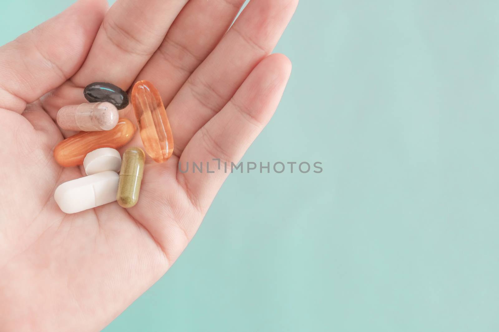 Top view of alternative organic medicine or herbal viatmin supplement capsule tablet on woman hand with copyspace background. by Suwant