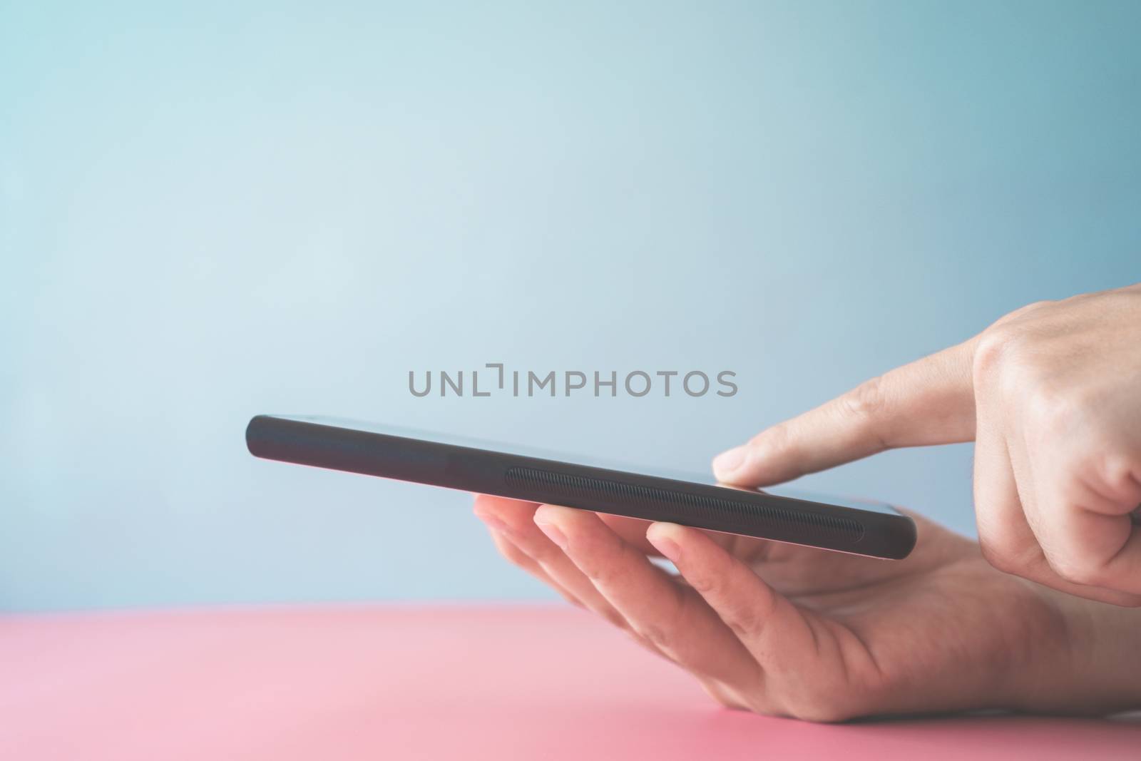 People hand using smartphone with blank pastel clear background. Business, financial, trade stock maket and social network concept.