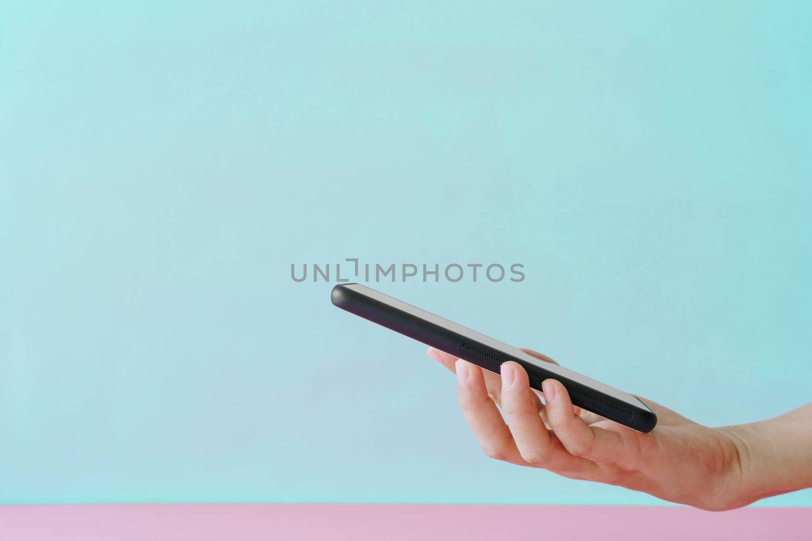 People hand using smartphone with blank pastel clear background. Business, financial, trade stock maket and social network. by Suwant