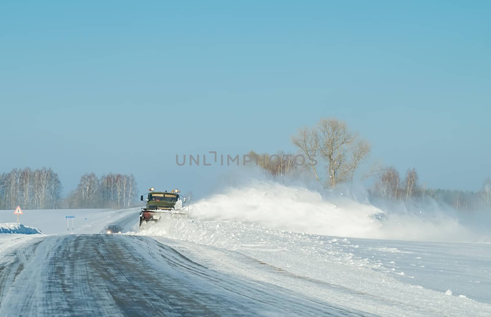 snow removal equipment, truck, winter clears the snow from the icy country road by jk3030
