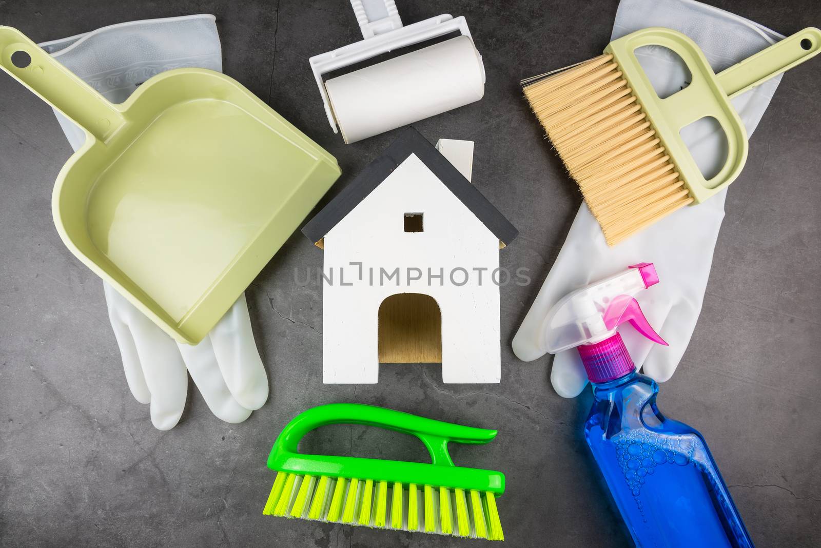 Wooden model white houses and house cleaning equipment on cement gray background. Concept Clean house Keep house clean.