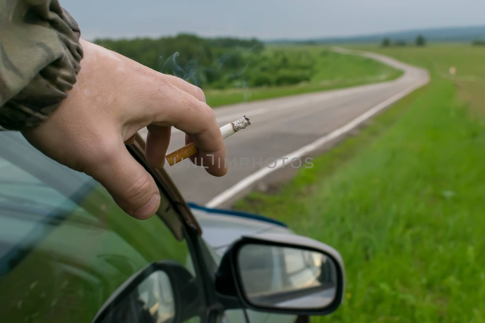 hand with a cigarette near the car by jk3030