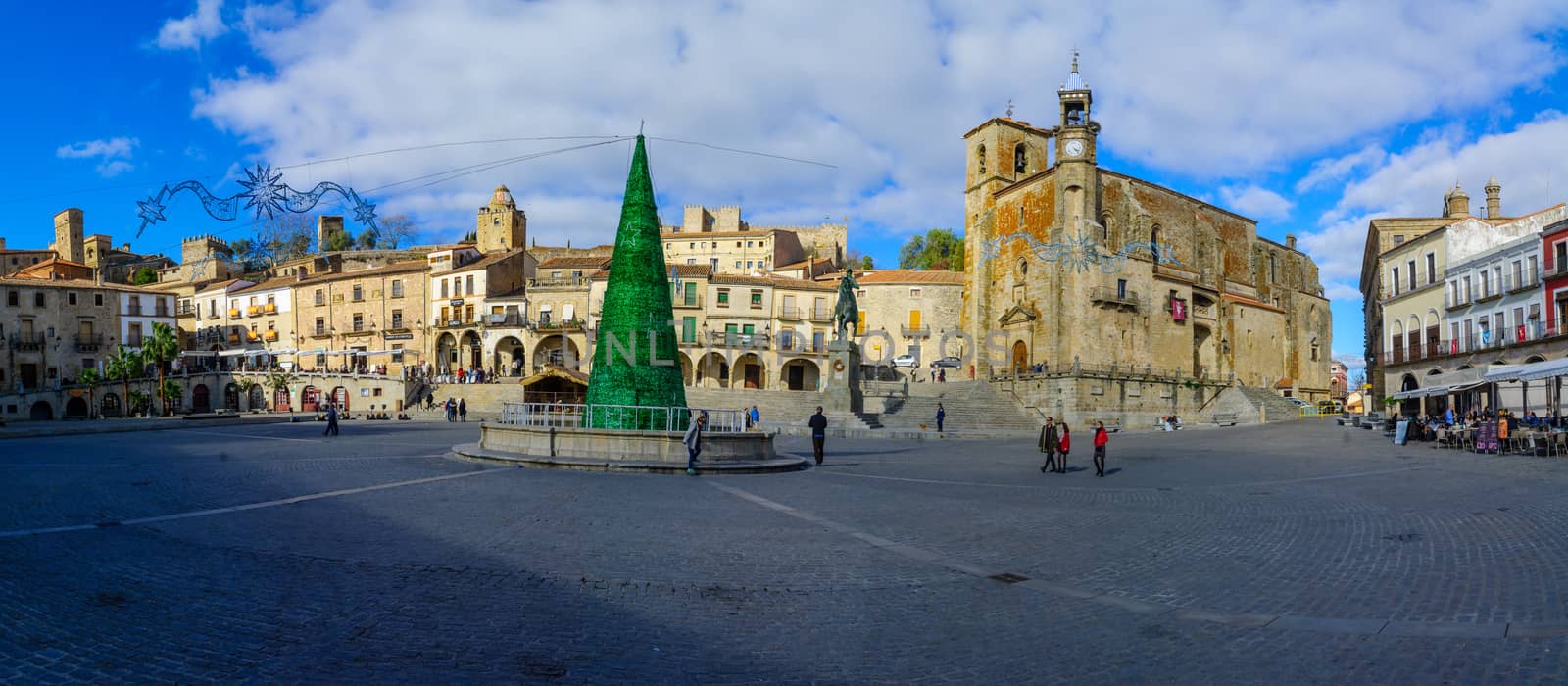 TRUJILLO, SPAIN - DECEMBER 30, 2017: Panoramic view of Plaza Mayor, with San Martin church, a Christmas tree, locals and visitors, in Trujillo, Extremadura, Spain